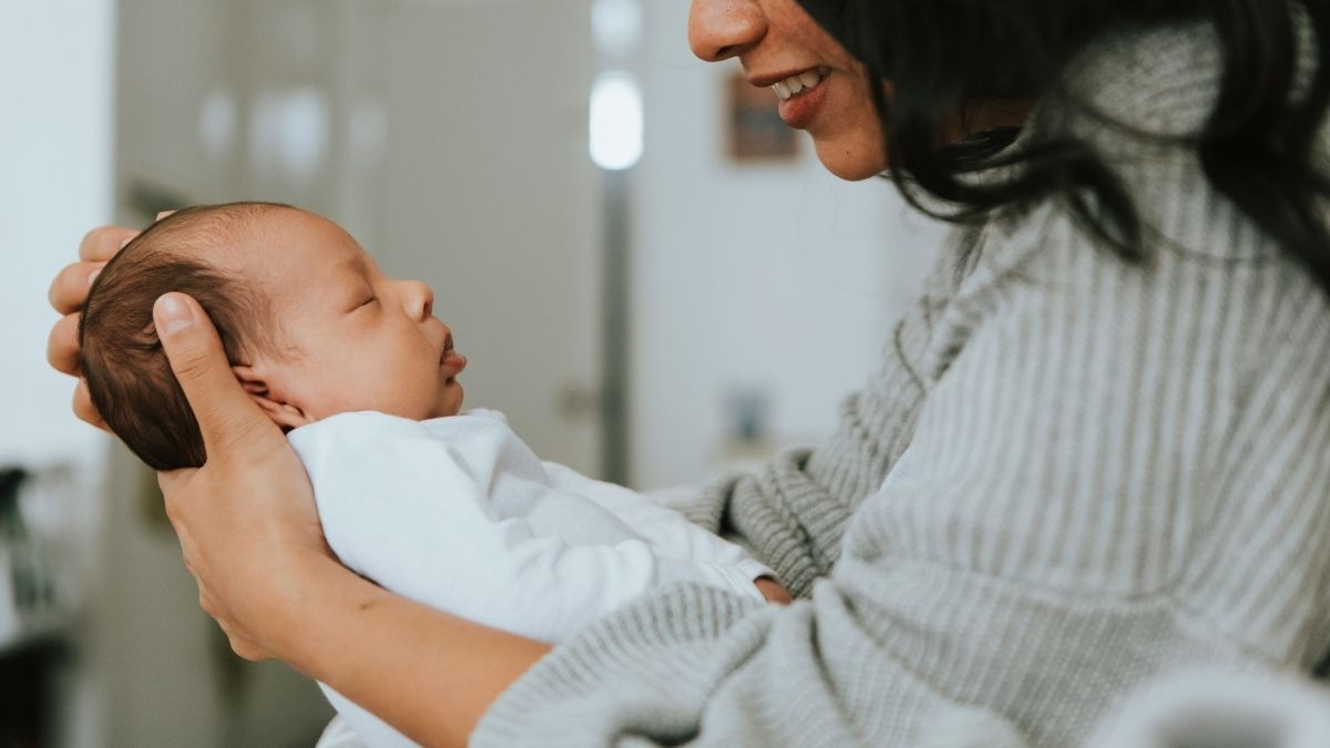 mother smiling at her baby while holding